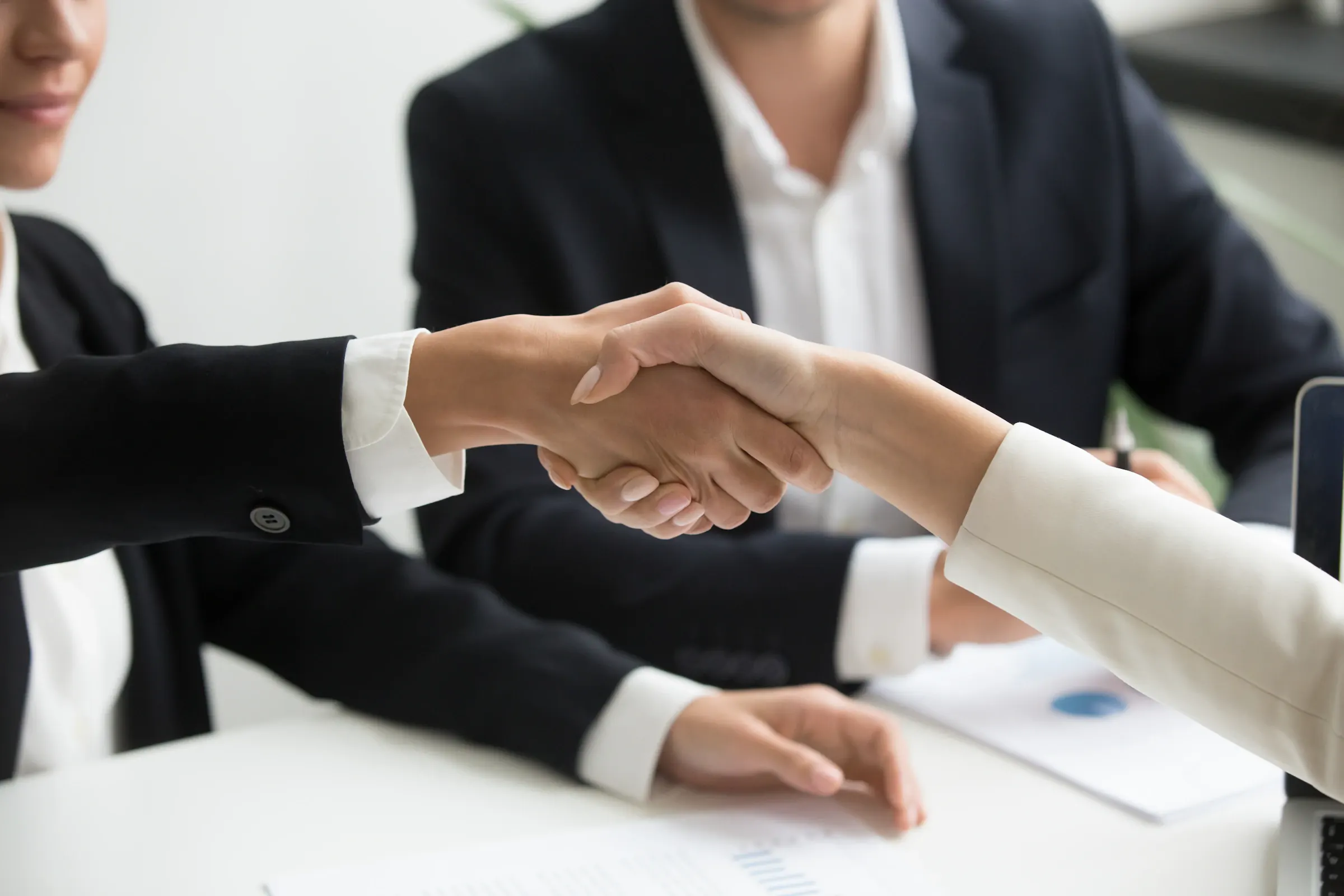 Two business professionals shaking hands over a trade agreement
