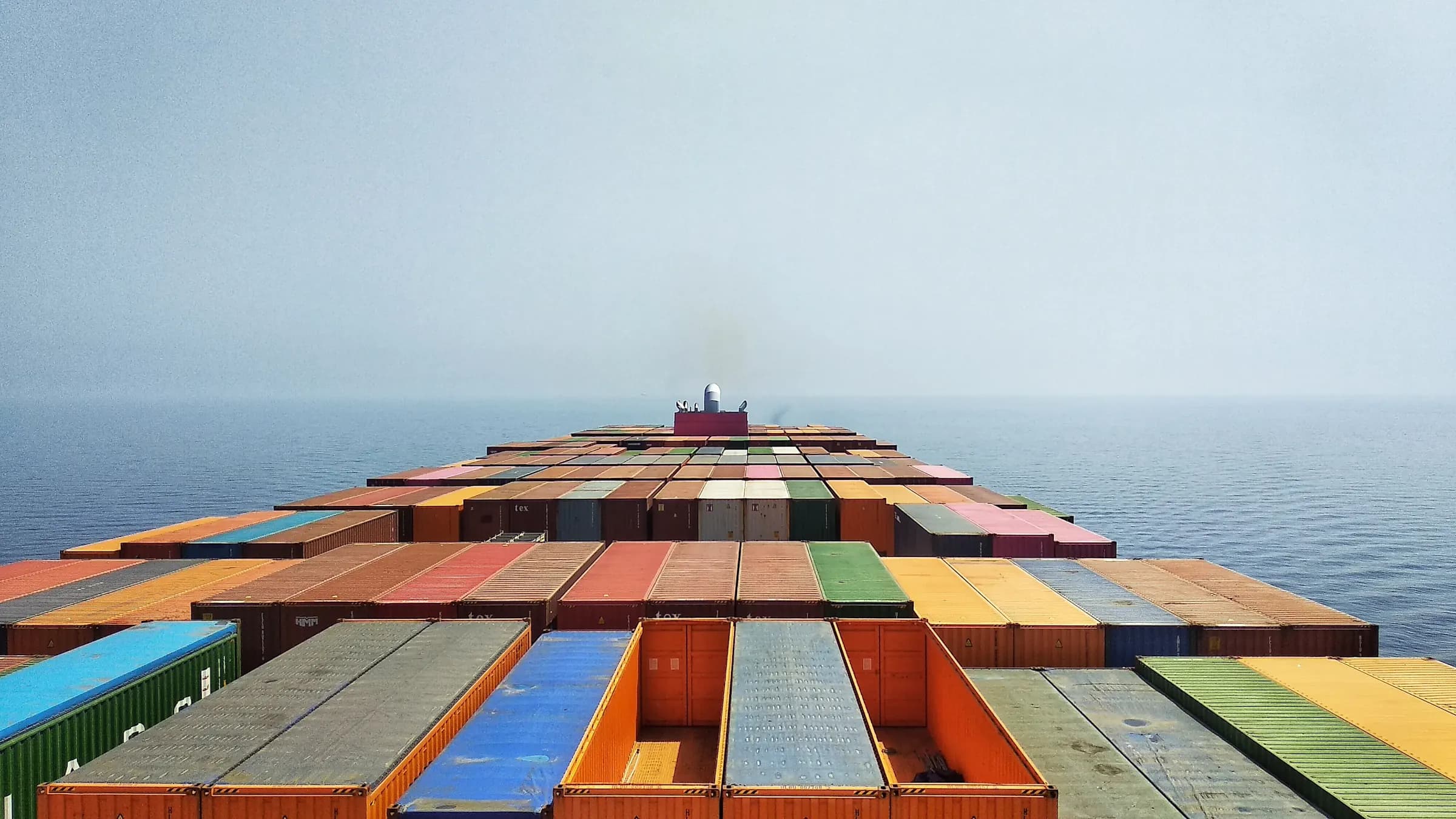 View along the deck of a container ship sailing through open water