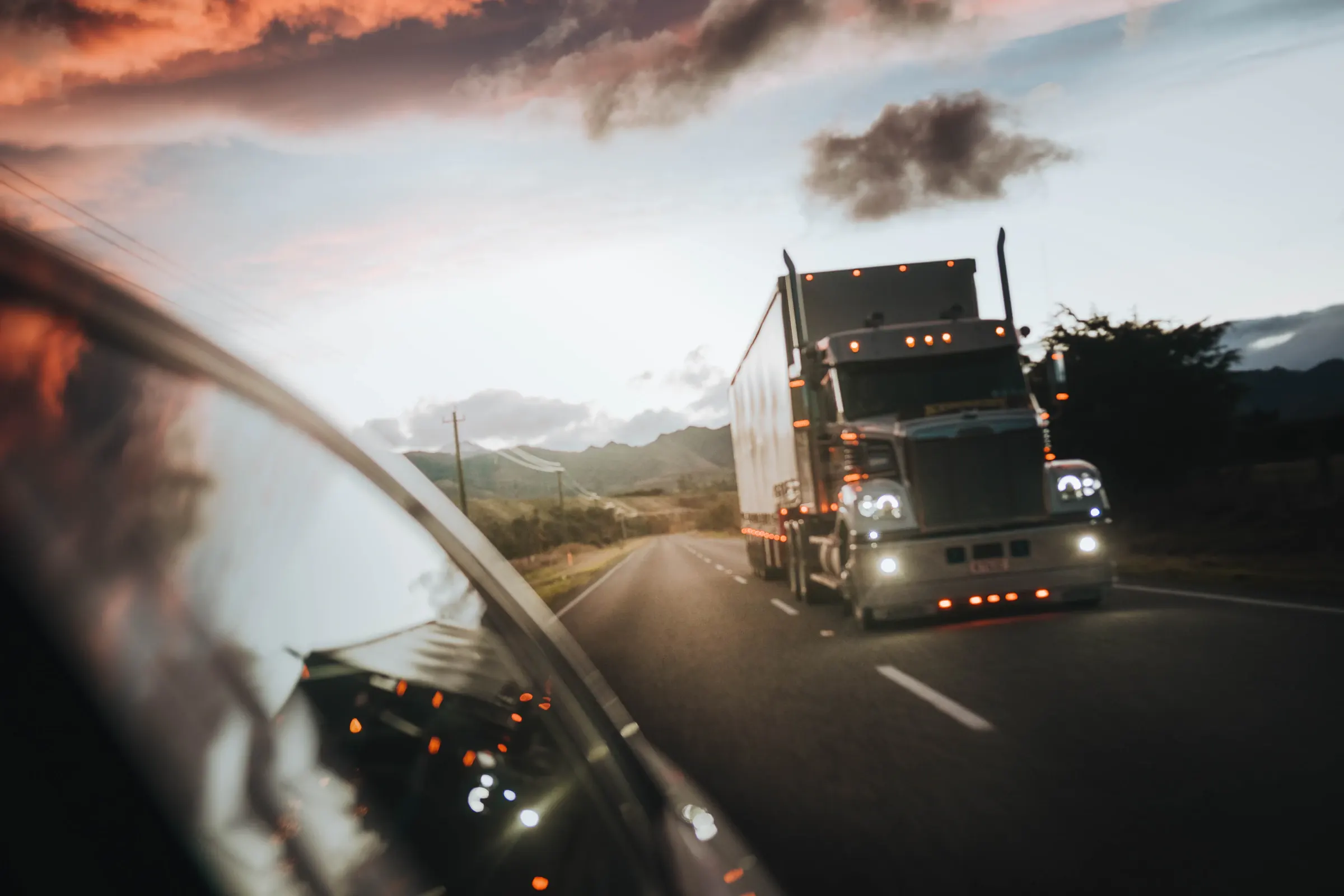 Cargo truck driving on a highway at dusk
